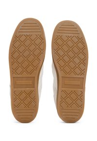 Suole di sneakers bianche con una texture in gomma decorata, caratterizzate da una suola in gomma marrone e il marchio "TOMMY HILFIGER" inciso.