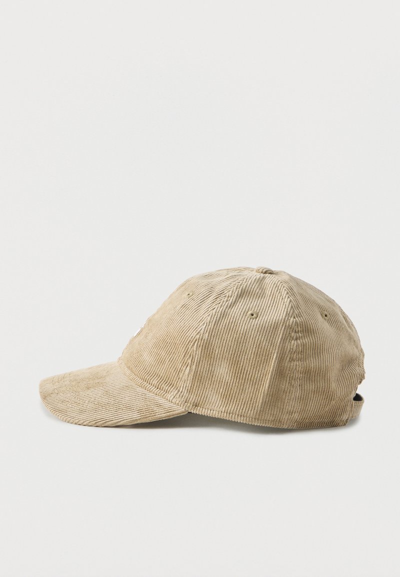 Beige Cord-Baseballmütze mit gebogenem Schirm, sechsteiliger Konstruktion und verstellbarem Riemen auf der Rückseite, seitlich auf weißem Hintergrund gezeigt.