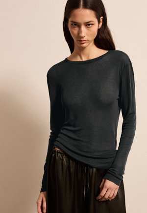 Schwarzes Langarmshirt mit rundem Halsausschnitt, aus weichem Stoff, kombiniert mit dunklen, glänzenden, elastischen Hosen mit elastischem Bund. Glatte Textur, taillierte Passform.