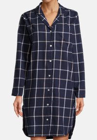 Vestito blu navy a maniche lunghe con motivo a griglia grigio chiaro e beige, chiusura a bottoni frontale, colletto e una tasca sul petto.