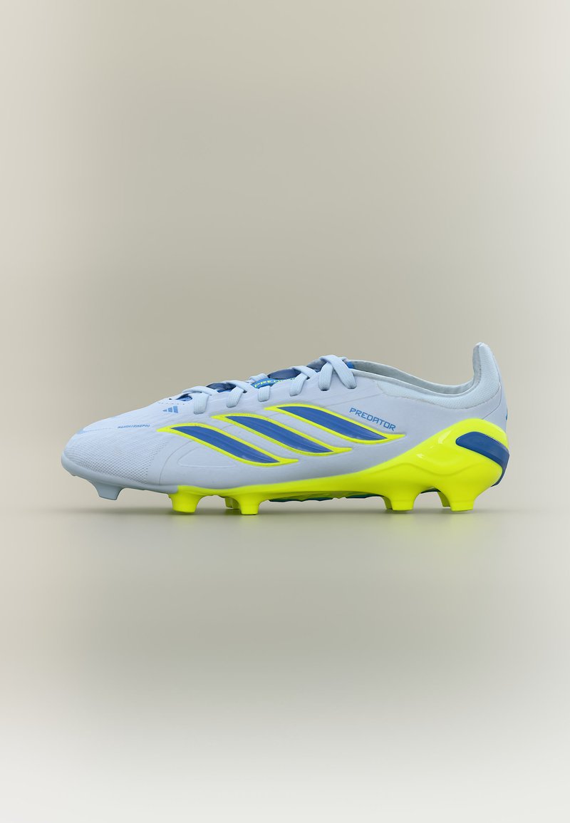 Chaussure de football Adidas Predator blanche et jaune néon avec détails et crampons bleus, montrée de profil sur un fond beige.