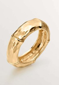 Anillo de oro en forma de bambú con textura martillada, con bordes suaves y curvados y sutiles separaciones entre los segmentos.