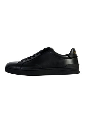 Zapatilla de cuero negro con punta redondeada, costuras tonales, cierre de cordones y un acabado mate liso. Presenta un sutil logo en el talón.