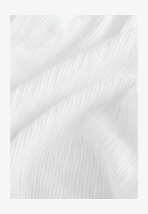 Bílá texturovaná látka s vlnitým vzorem, která má jemné rýhy a měkký, hladký povrch. Světlo se jemně odráží od materiálu.