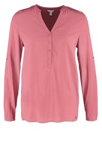 Blouse rose à manches longues avec col en V, patte de boutonnage et détails de patte d'épaule.