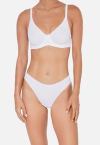 Soutien-gorge en coton blanc avec des bonnets moulés et des bretelles ajustables, associé à un string en coton blanc au design bas et aux coutures minimales.