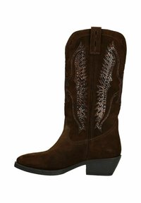 Bottes de cowboy en daim marron avec un bout pointu, des découpes raffinées et un petit talon empilé. Comprend une couture décorative sur la tige.