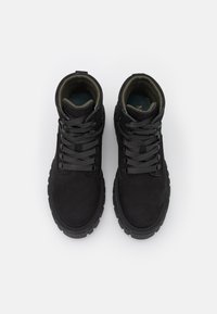 Paire de bottes de randonnée noires à lacets avec semelles épaisses et col rembourré, vue de dessus sur fond blanc.