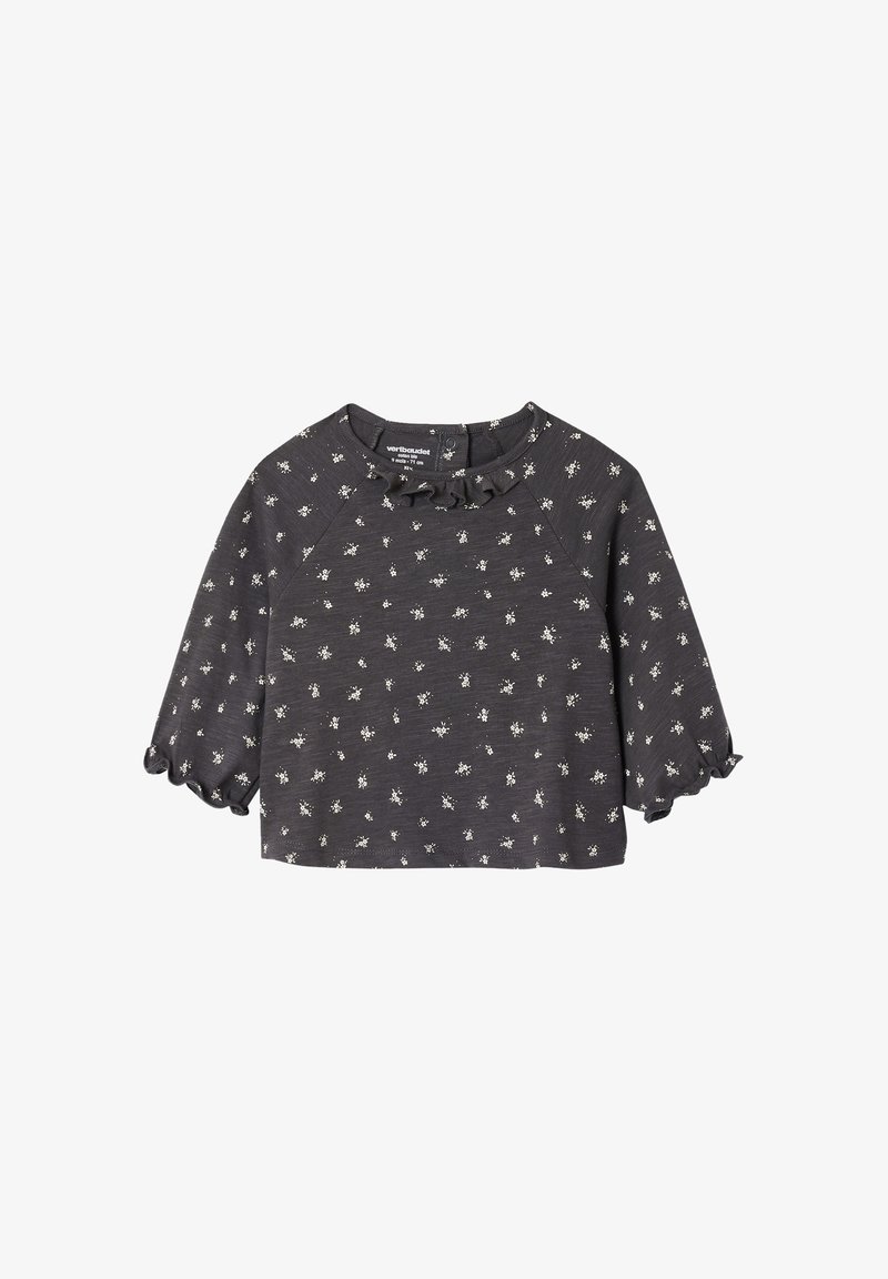 Dunkelgraues kurzärmliges Oberteil mit einem volantschulterartigen Halsausschnitt und weißen Blumenmustern. Weicher Stoff mit lockerer Passform und leicht ausgestellt Ärmeln.