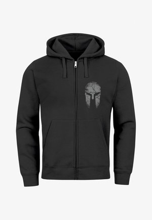 Black zip-up hoodie made of soft fabric, featuring a cracked skull design in gray on the left chest. Includes front pockets and drawstring hood.