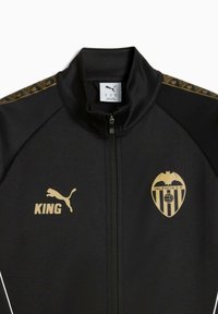 Svart zip-up jacka med guld accenter, inklusive Valencia C.F. logotyp och texten "KING", med mönstrade detaljer på axlarna.