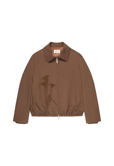 Giacca marrone con zip, collo, vita elastica e due tasche laterali, mostrata su sfondo bianco.