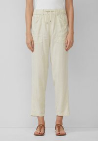 Lichtbeige linnen broek met een elastische tailleband, verstelbaar trekkoord en twee voorzakken. Geaccentueerd met een ontspannen, recht gesneden pijp.