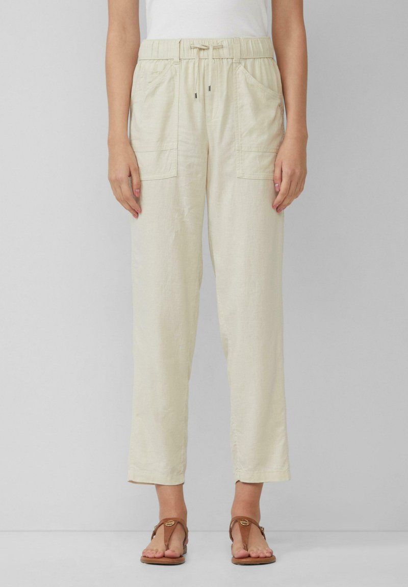Lichtbeige linnen broek met een elastische tailleband, verstelbaar trekkoord en twee voorzakken. Geaccentueerd met een ontspannen, recht gesneden pijp.