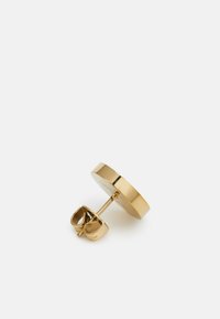 Orecchino a cerchio in oro, caratterizzato da una superficie liscia e lucidabile e un piccolo perno sul retro per una vestibilità sicura. Design semplice e moderno.