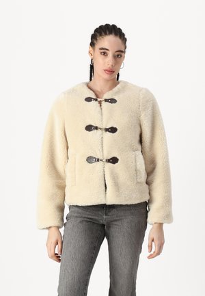 Giacca in pelliccia sintetica color crema con scollatura rotonda, dotata di chiusure a toggle marroni e due tasche frontali. Texture morbida, vestibilità rilassata.