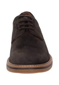Bruine suede veterschoen met een ronde neus, contrasterende bruine rubberen zool en zichtbare stiksels langs de randen van de zool.