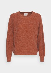Pull en maille couleur rouille avec un col rond, des manches longues et une coupe légèrement ample. La texture semble douce et confortable, avec un motif subtil.