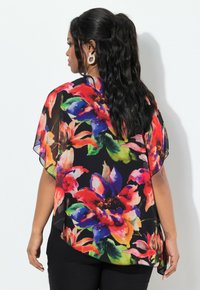Transparente Kimono-Bluse mit floralem Muster in lebendigem Rot, Blau und Grün auf einem schwarzen Hintergrund; fließendes Design mit kurzen Ärmeln.