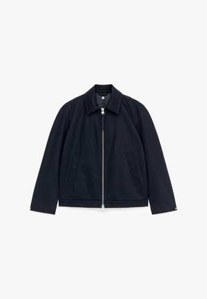 Donkerblauwe jas met een rits en kraag, twee voorzakken, lange mouwen en drukknopen aan de manchetten, plat gelegd op een witte achtergrond.