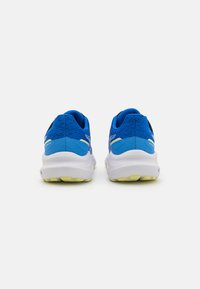 Baskets de sport bleues avec une tige en mesh texturé, une semelle intermédiaire blanche et des accents jaunes sur la semelle extérieure. Talon renforcé pour un meilleur soutien.