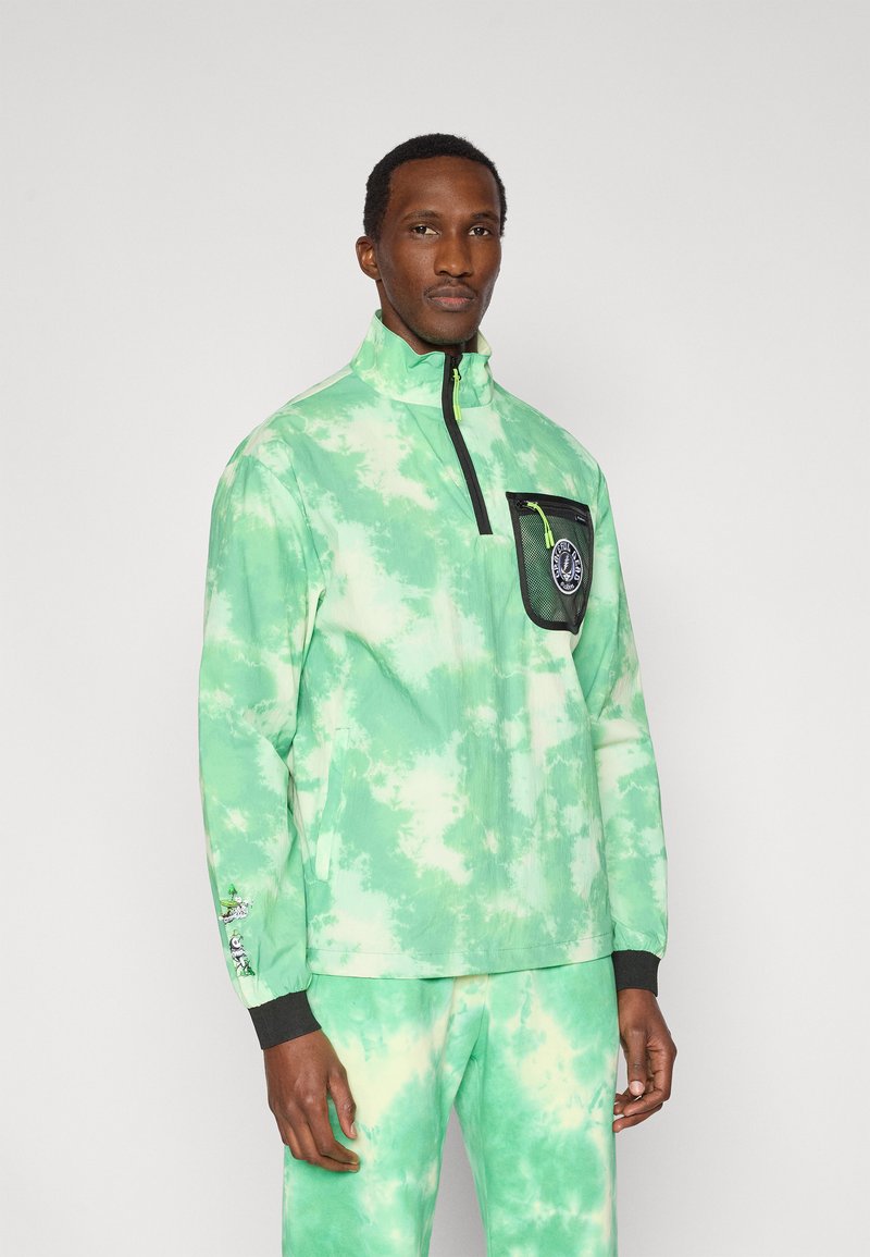 Πράσινο μπουφάν με εφέ γραβιέρας, υψηλό γιακά, τσέπη στο στήθος και μαύρο φερμουάρ. Διαθέτει ελαστικά μανσέτα και εμφανές λογότυπο στην τσέπη.