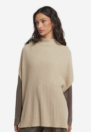 Beige geripptes Poncho mit hohem Kragen, lockerer Passform und weicher Textur. Die Ärmel sind braun und erzeugen einen geschichteten Look.