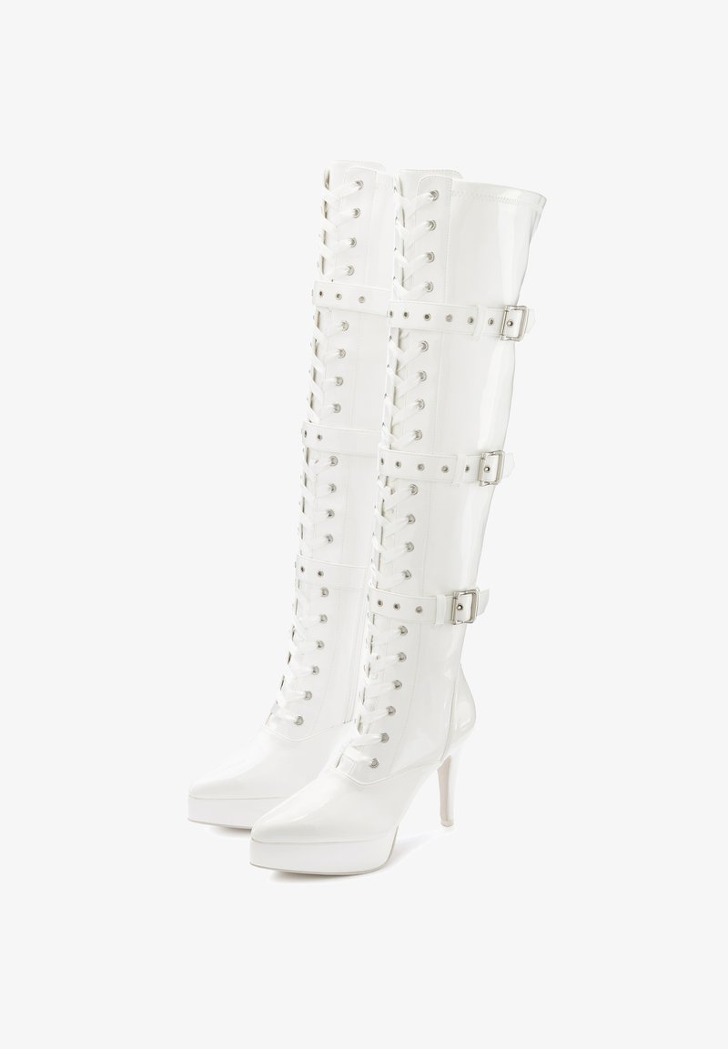 White patent leather knee-high boots with a pointed toe, lace-up front, and three buckle straps; features a high stiletto heel and platform sole.