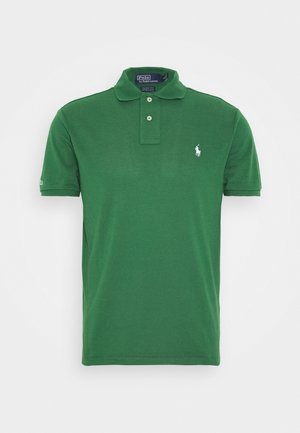Grøn poloshirt med korte ærmer, to knapper, en krave og en lille hvid broderet logo på venstre bryst.