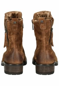 Botas de tobillo de ante marrón con forro de piel, cremalleras traseras y un tacón de madera bajo. Presenta un pequeño logotipo y una tela texturizada.