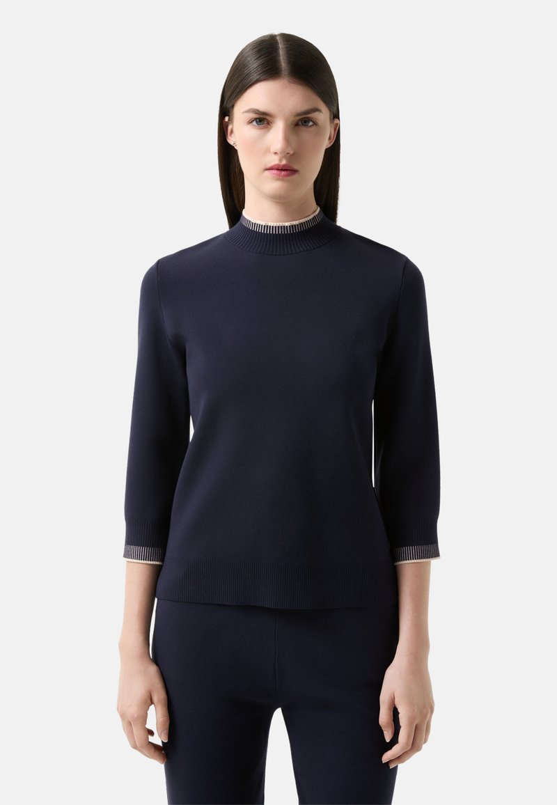 Marineblauer Pullover mit ribbeligem Stehkragen und Dreiviertelärmeln. Mit kontrastierenden gestreiften Bündchen. Glatte Stricktextur.