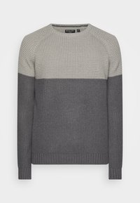 Grå stickad tröja med ett strukturerat mönster. Har en ljusare grå överdel och en mörkare grå underdel. Rund halsringning och ribbade ärmslut.