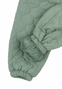 Giacca trapuntata verde con motivo a scacchi, caratterizzata da polsini elasticizzati e una consistenza morbida. Il design include dettagli arricciati sulle maniche.