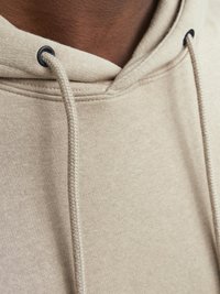 Beige hoodie with a drawstring, featuring a textured fabric. Eyelets for the drawstring are black, and seams are neatly stitched.