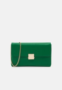Bolso de mano de cuero verde con una correa de cadena dorada, forma rectangular y un detalle de cierre cuadrado. Textura suave, diseño minimalista.