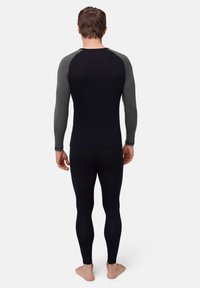 Black long-sleeve base layer with gray raglan sleeves and matching fitted leggings, made from a lightweight, stretchy fabric.