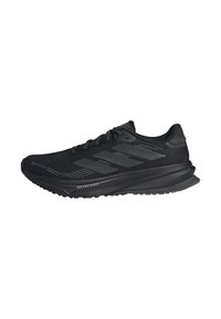 Scarpa da corsa nera Adidas con tomaia in Gore-Tex, tre righe sul lato e "Dreamstrike" sulla suola, vista dal lato esterno.