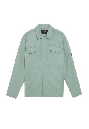 Hellgrüne Jacke aus Baumwolle mit einer Knopfleiste vorne, zwei Brusttaschen und einem gelben Logo-Detail am linken Ärmel.