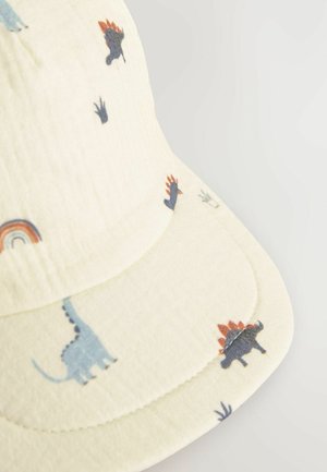 Cream-colored cap with a textured fabric, featuring colorful dinosaur and rainbow patterns on the front and side of the brim.