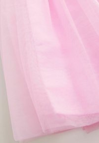Ljusrosa tylltyg med mjuk, genomskinlig textur, som har ett subtilt, luftigt fall och minimala synliga sömmar.