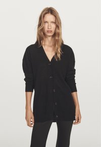 Black cardigan made of soft fabric, featuring a V-neck, long sleeves, and button-front closure. Simple design with relaxed fit.