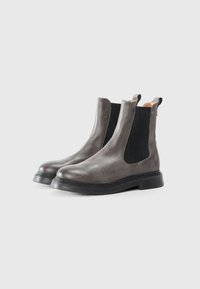 Bottines Chelsea en cuir gris avec des panneaux latéraux élastiques, bout arrondi et semelles en caoutchouc noir. Dotées d'une languette au talon pour un enfilage facile.