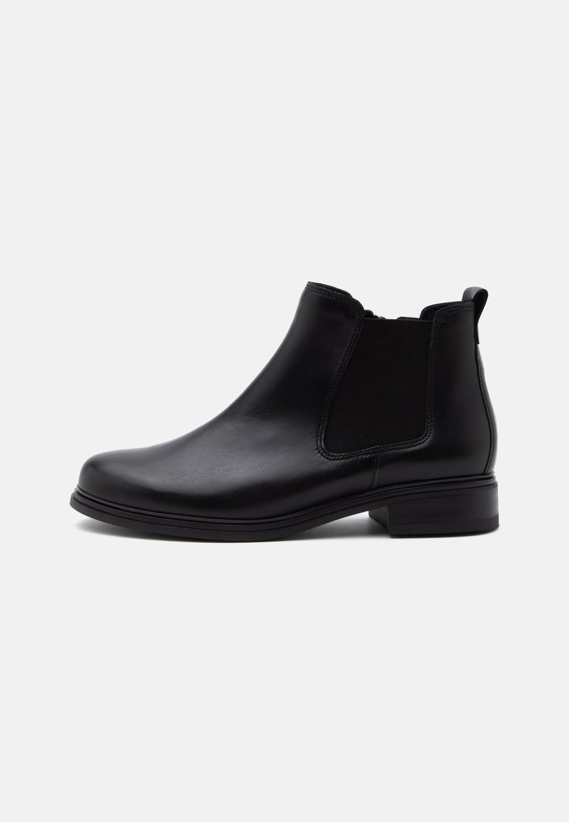 Bottine Chelsea en cuir noir à la cheville avec panneaux latéraux élastiques et petit talon empilé sur un fond clair uni.