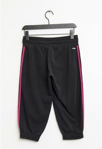 Schwarze, kurze Sweatpants sind mit einem dehnbaren Bund, rosa Seitenstreifen und enganliegenden Bündchen ausgestattet. Weicher Stoff mit glatter Textur.