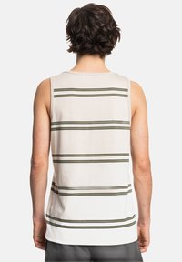 Camiseta sin mangas blanca con rayas horizontales verdes. Tejido suave, diseño sin mangas y corte recto. Etiqueta visible en el cuello de la parte trasera.