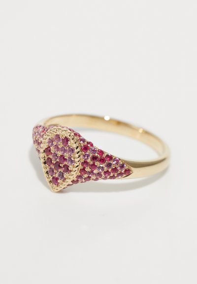 Anello d'oro con un cluster a forma di goccia di piccoli gemme rosa e rosse, circondato da un bordo d'oro intrecciato.