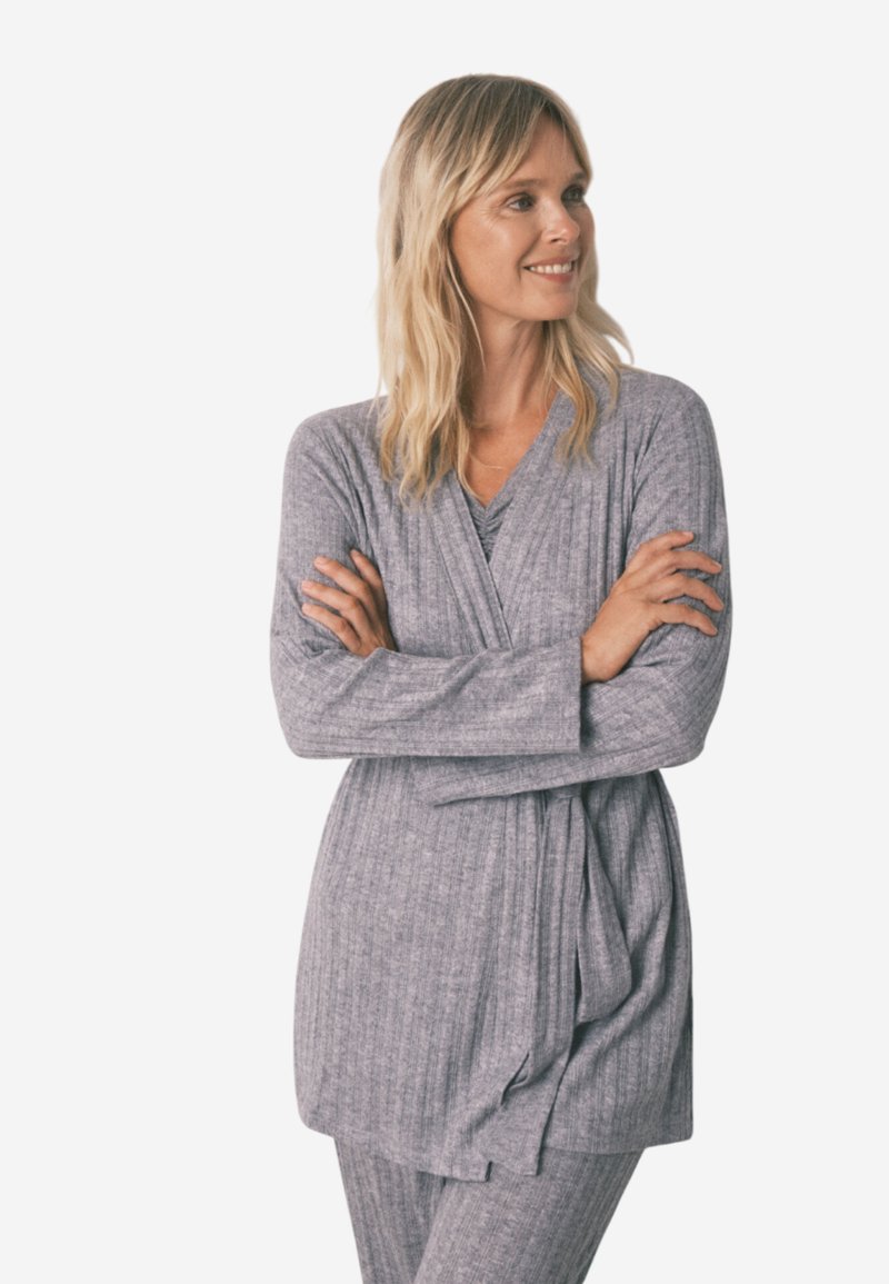 Ensemble de loungewear gris à côtes, composé d'un haut à manches longues croisé avec une taille à nouer, associé à un pantalon assorti, fabriqué à partir d'un tissu doux et texturé.