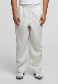 Hellebeige bukser i en linnedblanding med elastisk talje og sidelommer, med et løst, lige ben-design. Kombineret med sportssko.