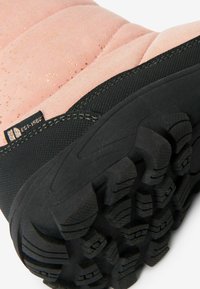 Stivale impermeabile rosa con una parte superiore testurizzata con lentiggini dorate, suola in gomma nera e un motivo di battistrada robusto per garantire aderenza.