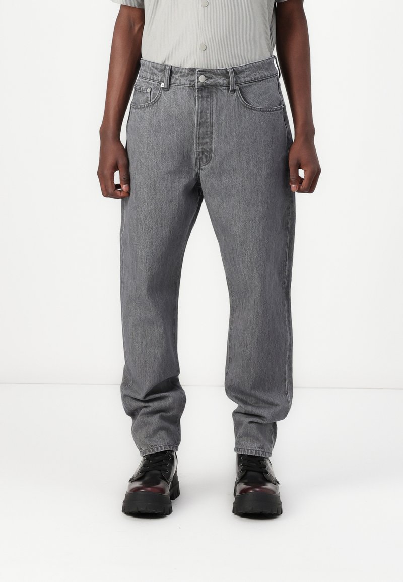 Grå denimjeans med en avslappet passform, fem lommer og knappelukking. Stoffet har en subtil tekstur og en lett falmet finish.